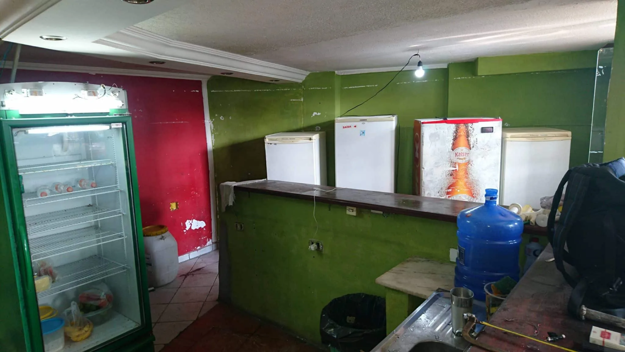 Área do bar antes da reforma Área do bar antes da reforma com balcões, geladeiras e diferentes acabamentos