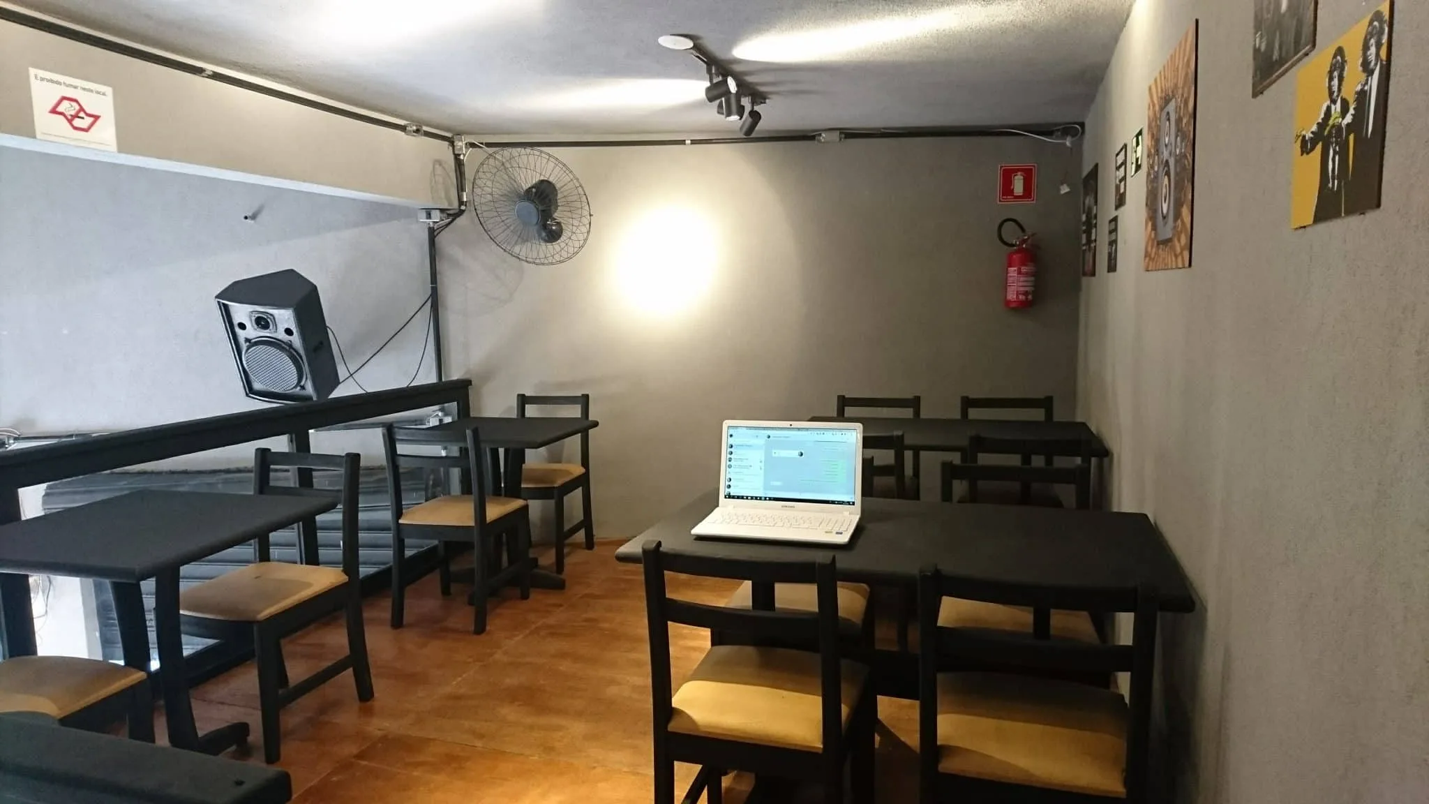 Mezanino reformado e mobiliado Mezanino reformado com mesas pretas, guarda-corpo escuro e iluminação em trilho