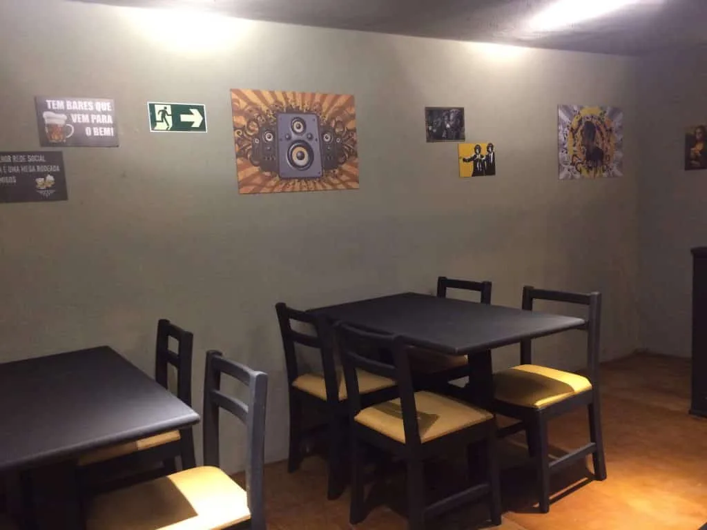 Mezanino depois da reforma Mezanino depois da reforma com mesas pretas, iluminação direcionada e paredes cinzas