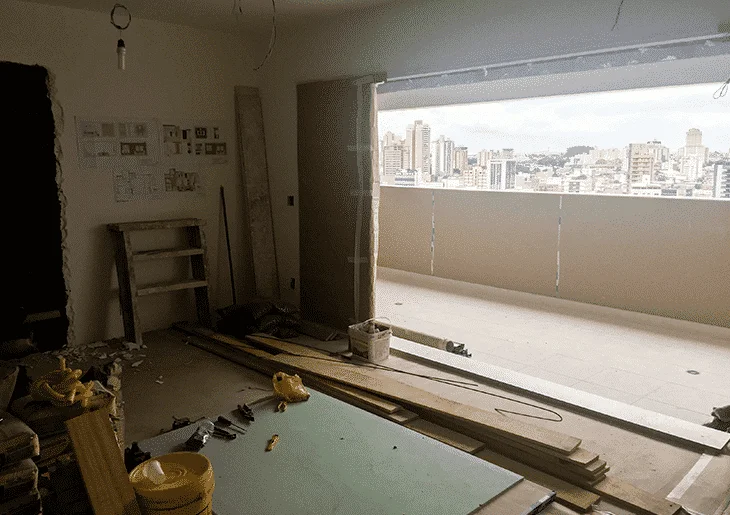Etapas de uma reforma residencial Apartamento durante reforma residencial com materiais de obra, paredes abertas e varanda