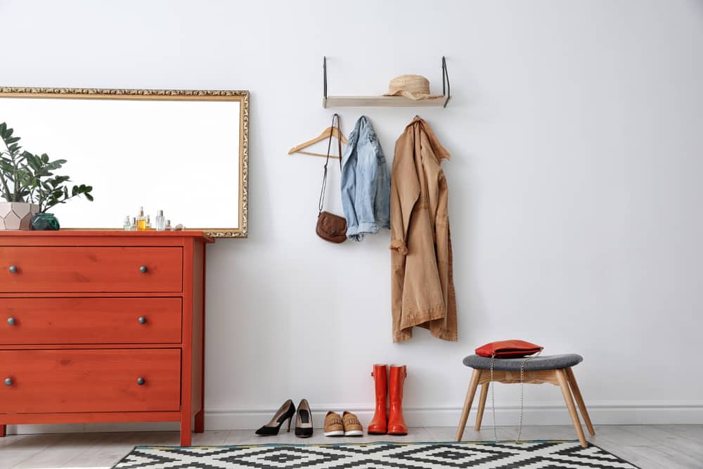 Espaço com comoda e ganchos na parede. Sala de Estar Organizada - 6 Dicas profissionais para guardar objetos!