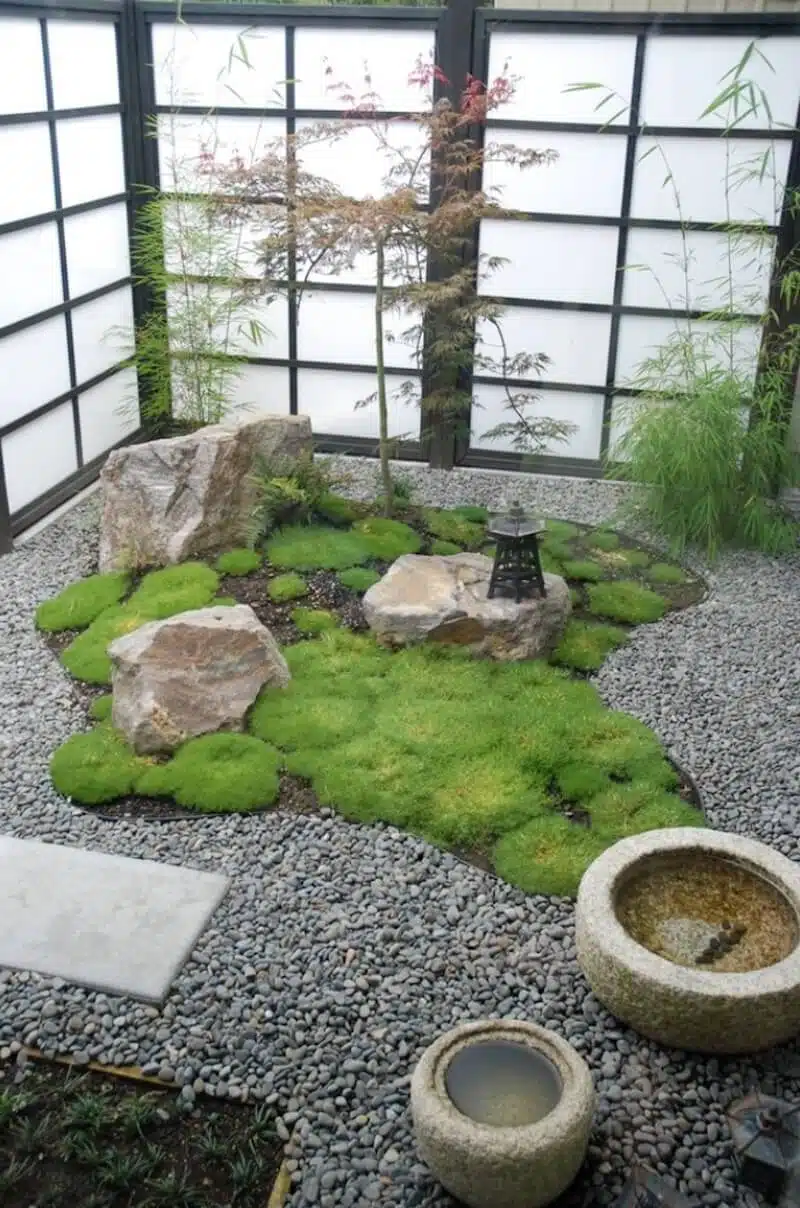 Jardim de inverno com pedras, musgo, bambus e fechamento translúcido