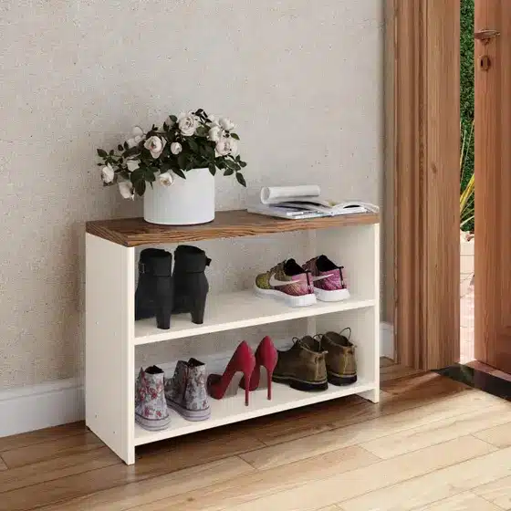 Como escolher os melhores móveis para hall de entrada? a shoe shelf with shoes and a plant on top