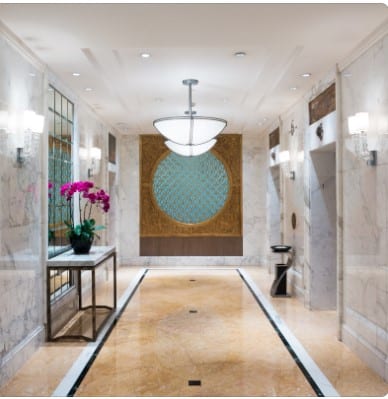 Como iluminar o hall de entrada? a hallway with marble floor and a flower pot