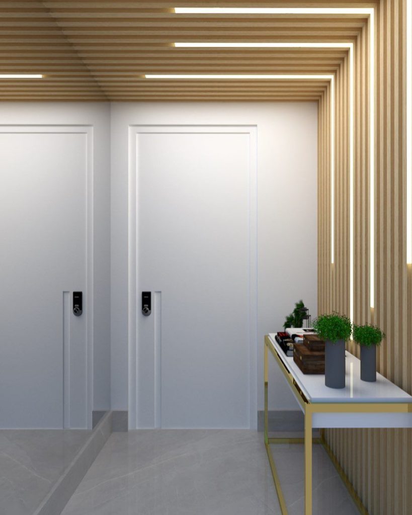 Como iluminar o hall de entrada? a white doors with a table and plants on it