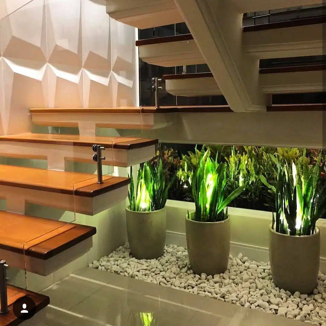 Jardim de inverno pequeno sob escada com vasos e pedras brancas