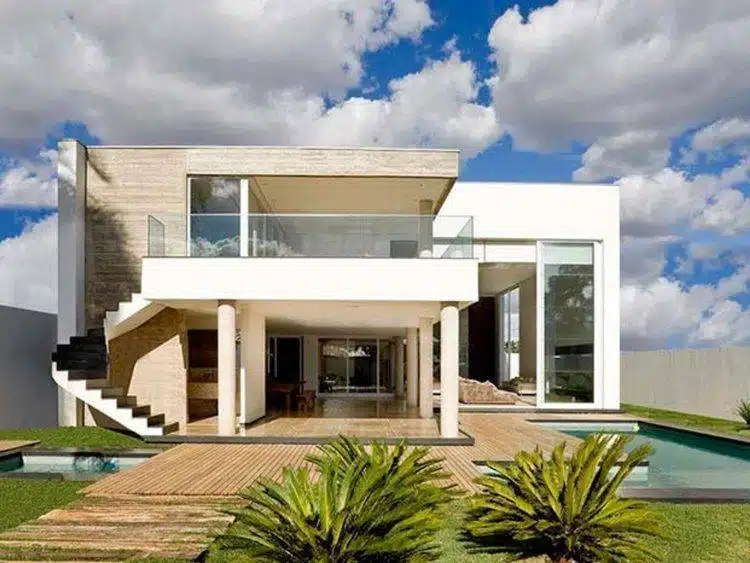 Casa caixote de dois pavimentos Sobrado contemporâneo com volumes retangulares, varanda e grandes aberturas