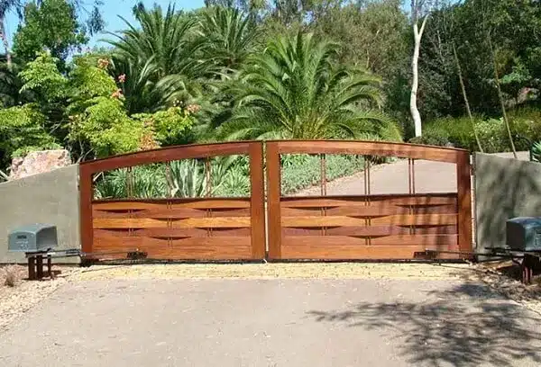 7 Ideias para Decorar a Entrada de Chácara 14 Portão de madeira fixado no muro de concreto que dá acesso à entrada de chácara.