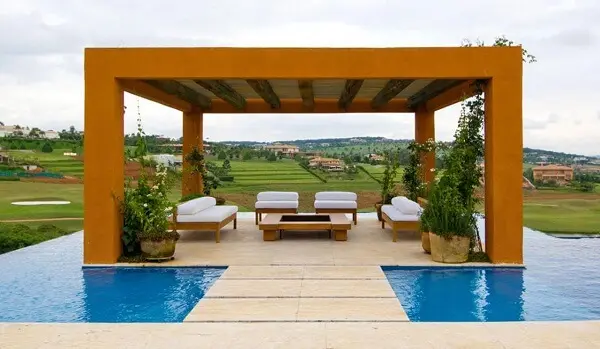 7 Ideias para Decorar a Entrada de Chácara 3 Varanda com sofá branco na área externa da casa de chácara.
