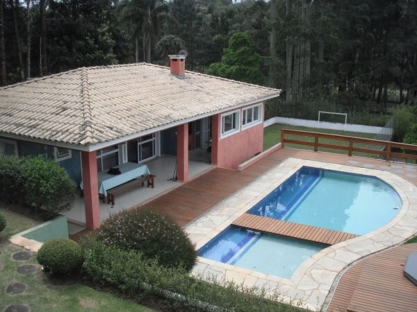 7 Ideias para Decorar a Entrada de Chácara 15 Parede com pintura vermelha e piscina com deck na casa de chácara.