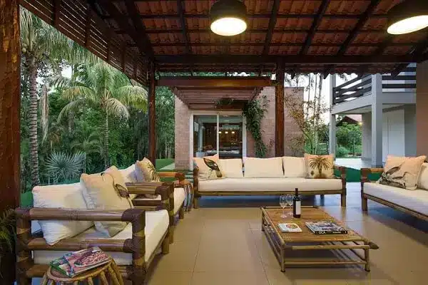 7 Ideias para Decorar a Entrada de Chácara 5 Varanda com móveis claros utilizados na casa de chácara.