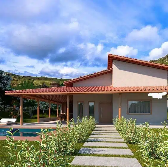 10 Ideias de Casas com Alpendre para se Inspirar e Construir a Sua 1 Casa com alpendre com estrutura de pilastras e bastante plantas ao redor.
