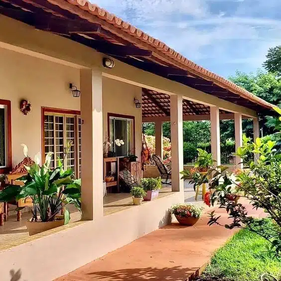 10 Ideias de Casas com Alpendre para se Inspirar e Construir a Sua 3 Casa com alpendre criando uma área aconchegante para relaxar, com bastante espaço externo.