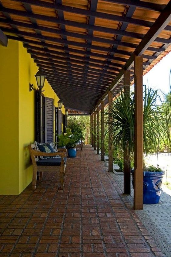 10 Ideias de Casas com Alpendre para se Inspirar e Construir a Sua 6 Área com alpendre com sofás e cadeiras, ideal para aproveitar com a família e amigos.