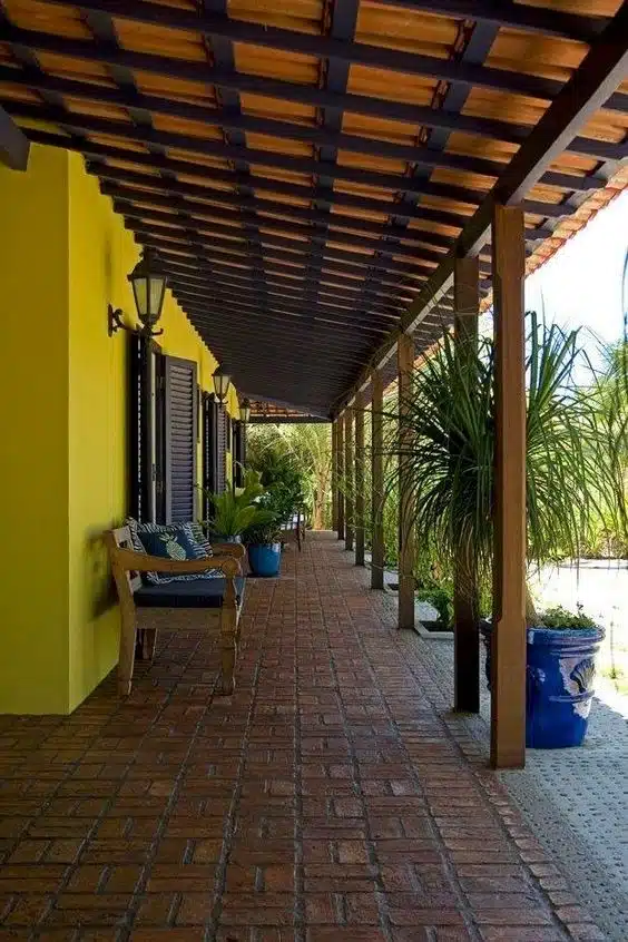 10 Ideias de Casas com Alpendre para se Inspirar e Construir a Sua 6 Área com alpendre com sofás e cadeiras, ideal para aproveitar com a família e amigos.