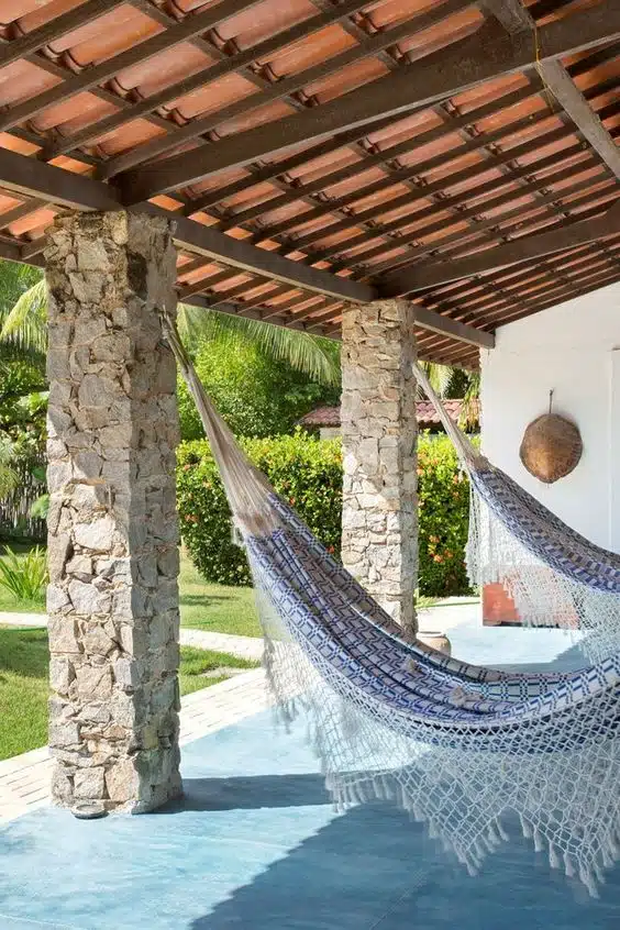 10 Ideias de Casas com Alpendre para se Inspirar e Construir a Sua 14 Uso das pilastras para incluir ganchos para redes, criando uma área de relaxamento.
