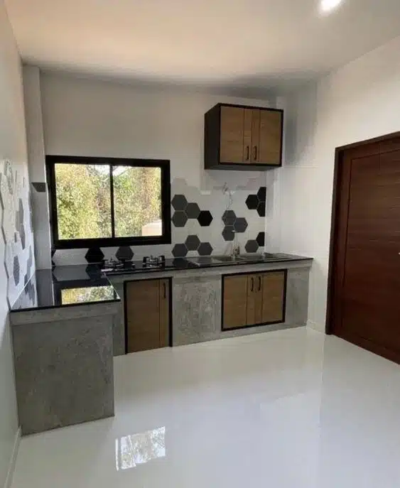 Cozinha pequena em L com bases cinza, portas de madeira e bancada escura