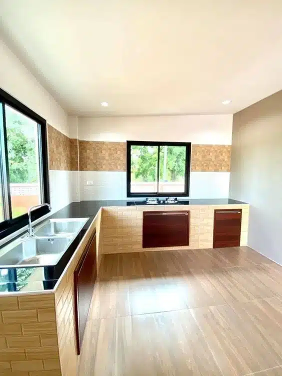 Cozinha em U com bases revestidas, portas escuras e bancadas pretas