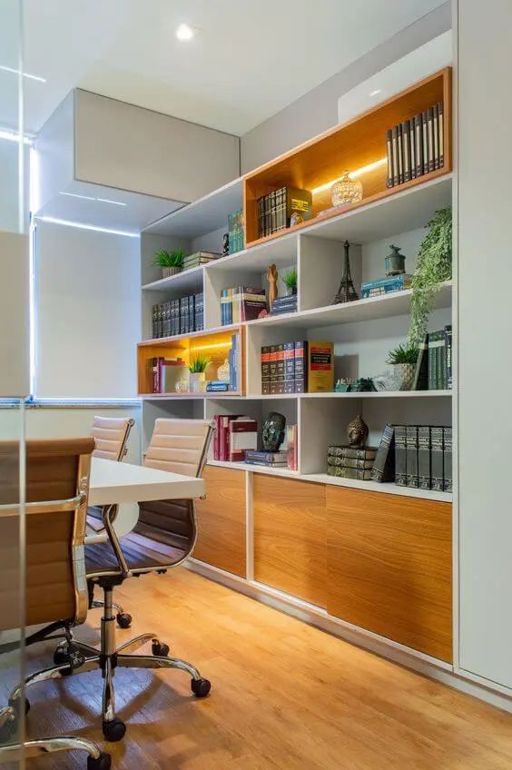 Escritório com Biblioteca: 25 exemplos para e crie um ambiente funcional e inspirador. Veja as sugestões! 15 Instalação dos livros em locais variáveis, o comum é que fiquem instalados atrás de você, gerando um plano de fundo ao cliente te ver.