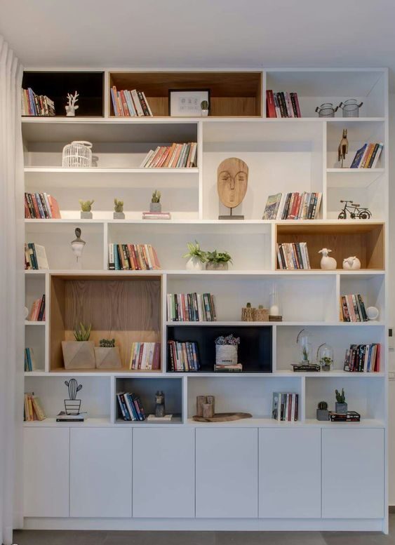 Escritório com Biblioteca: 25 exemplos para e crie um ambiente funcional e inspirador. Veja as sugestões! 16 Como uma estante pode ser organizada para termos uma biblioteca e ao mesmo tempo incluir elementos decorativos, gerando ligação e harmonia entre os itens.