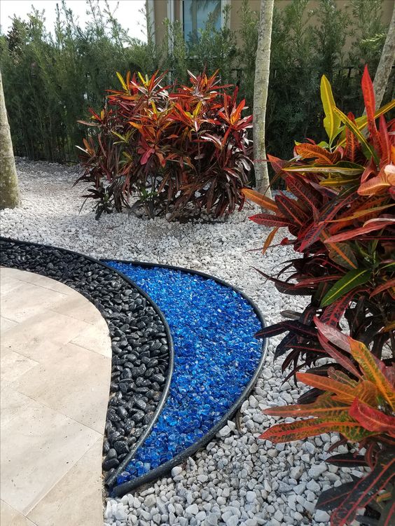 14 Ideias de Jardim com Pedras para Transformar sua Casa 1 1. Nesse cantinho do jardim, as pedras azuis deram o efeito de lago, com direito a um contorno bastante moderno feito com pedras pretas.