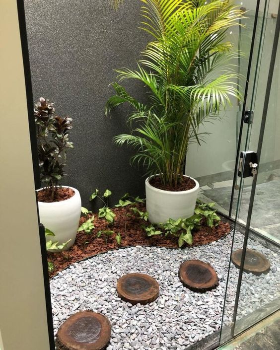 5. Nesse jardim de inverno, vemos modelos diferentes de pedra e um caminho com pedaços de troncos que se tornou muito interessante. Já para decorar a parede, um acabamento igualmente moderno.