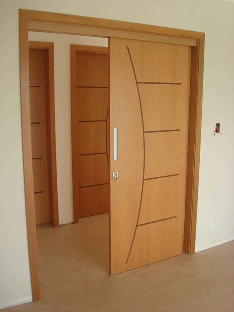 13 Modelos de Porta para Quarto que Você Vai Amar 4 Porta de correr de madeira para quarto, decorada com alguns riscos.