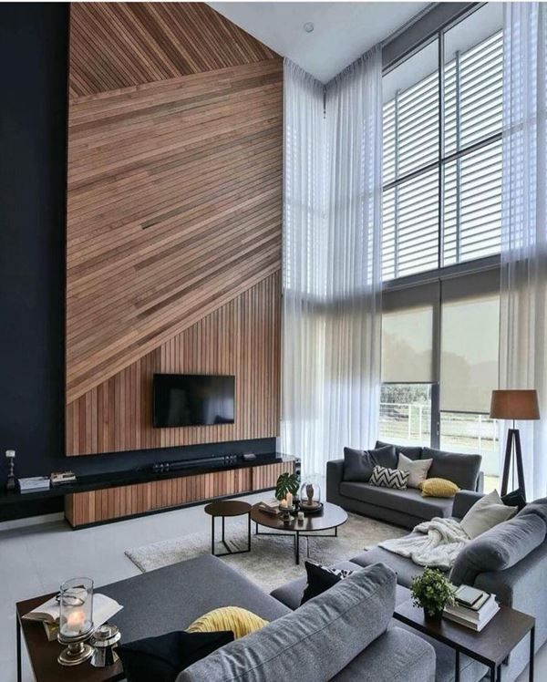 14 Inspirações Impressionantes para Sala com Pé Direito Duplo 8 Brincadeira com materiais e painéis de madeira.