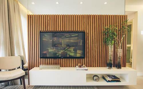 15 Ideias de Salas de TV Decoradas que Você Vai Adorar 8 Para inovar, um painel para TV com ripas de madeira para contrastar com os móveis mais modernos.