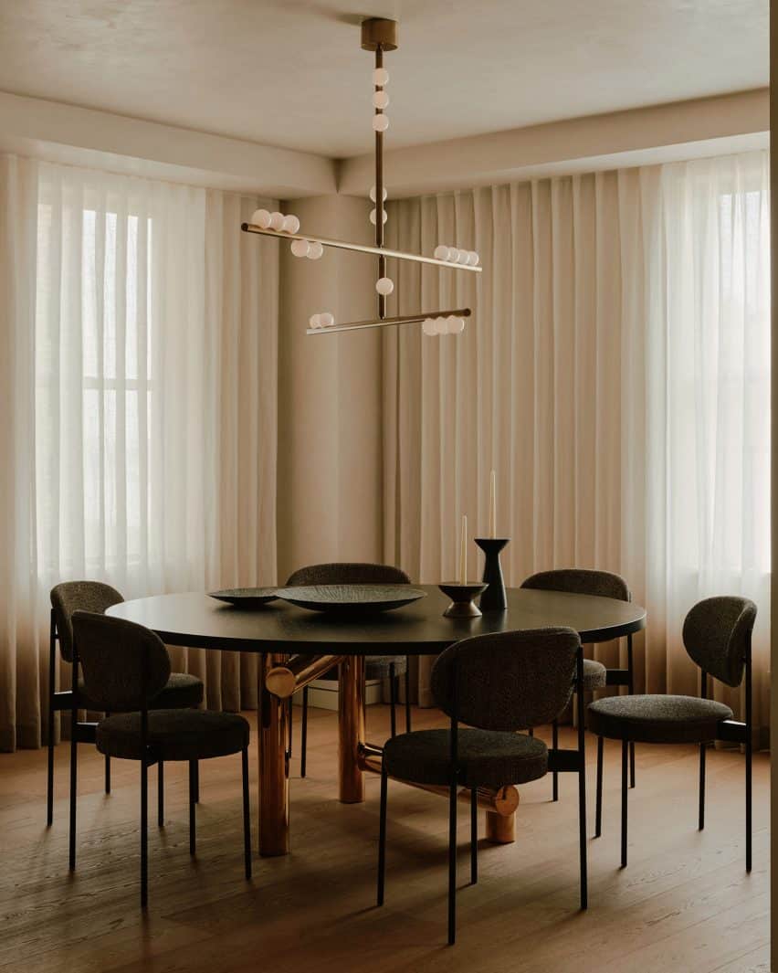 Transformação deslumbrante de apartamento em Manhattan. 2 Imagem da sala de jantar com cadeiras pretas, evidenciando o espaço central da casa.