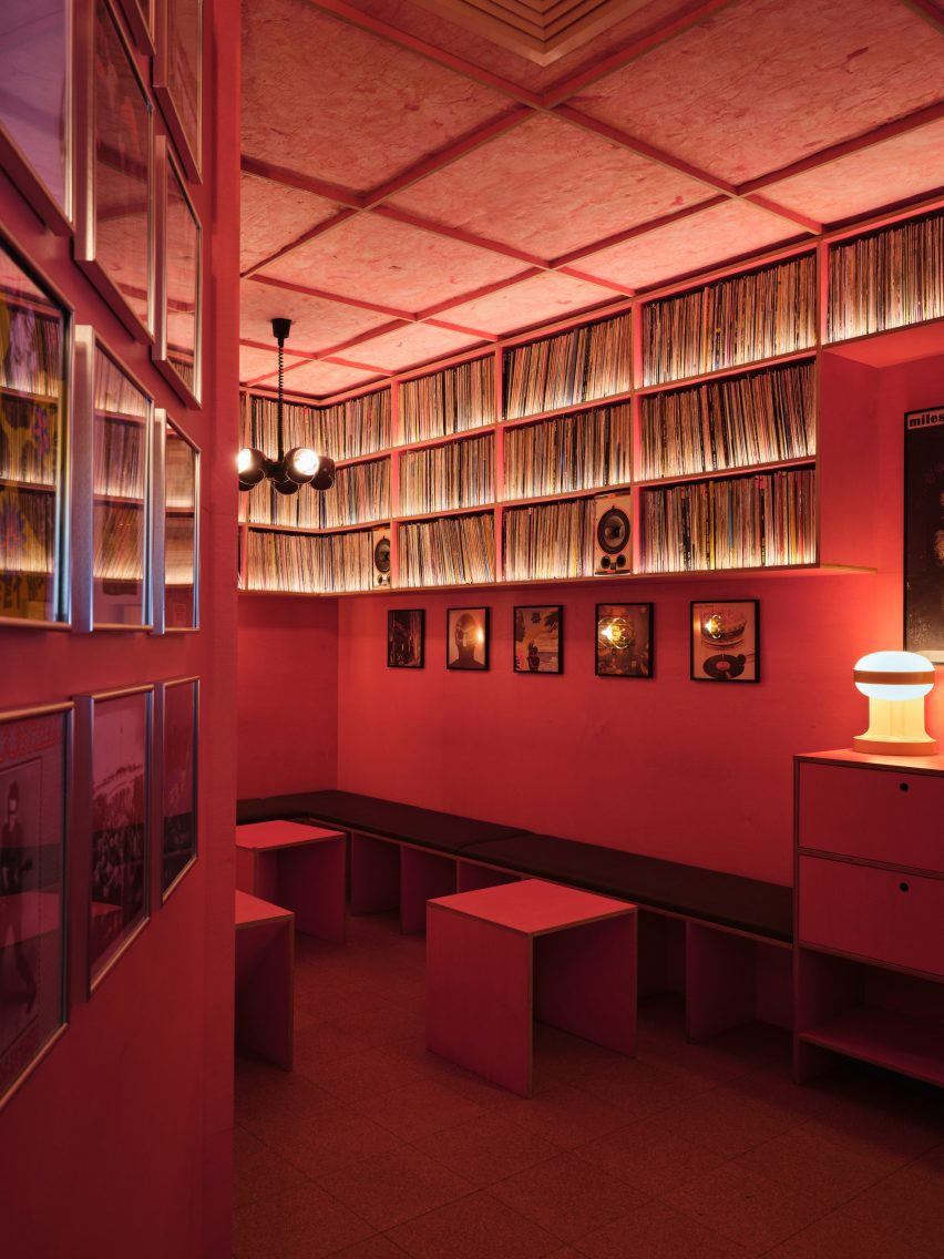 A biblioteca de discos montada no bar, apresentando coleções de vinil em um ambiente vibrante e elegante.