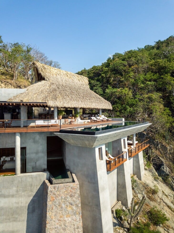 Arquitetura Sustentável: A Casa Acantilado no México 6 Imagem da casa destacando a técnica vernacular, com uso de materiais locais como pedra, madeira e folhas de palmeira.