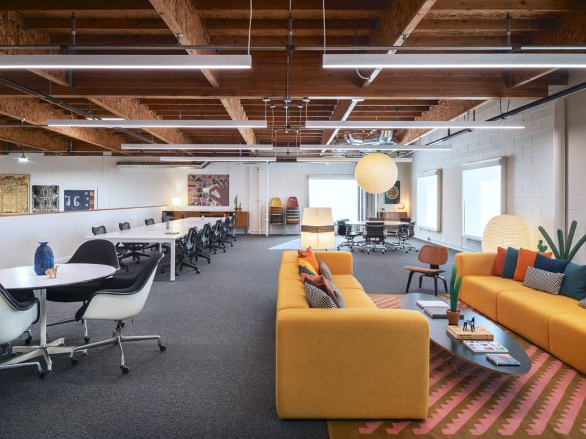 5 soluções criativas para a renovação do Eames Institute. 2 Sofá laranja na sede do Eames Institute, mostrando um ambiente colorido e acolhedor, projetado com móveis vintage.