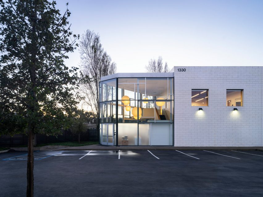 5 soluções criativas para a renovação do Eames Institute. 3 Imagem que destaca os escritórios na sede do Eames Institute, com estrutura exposta e um interior vibrante, repleto de móveis de design.