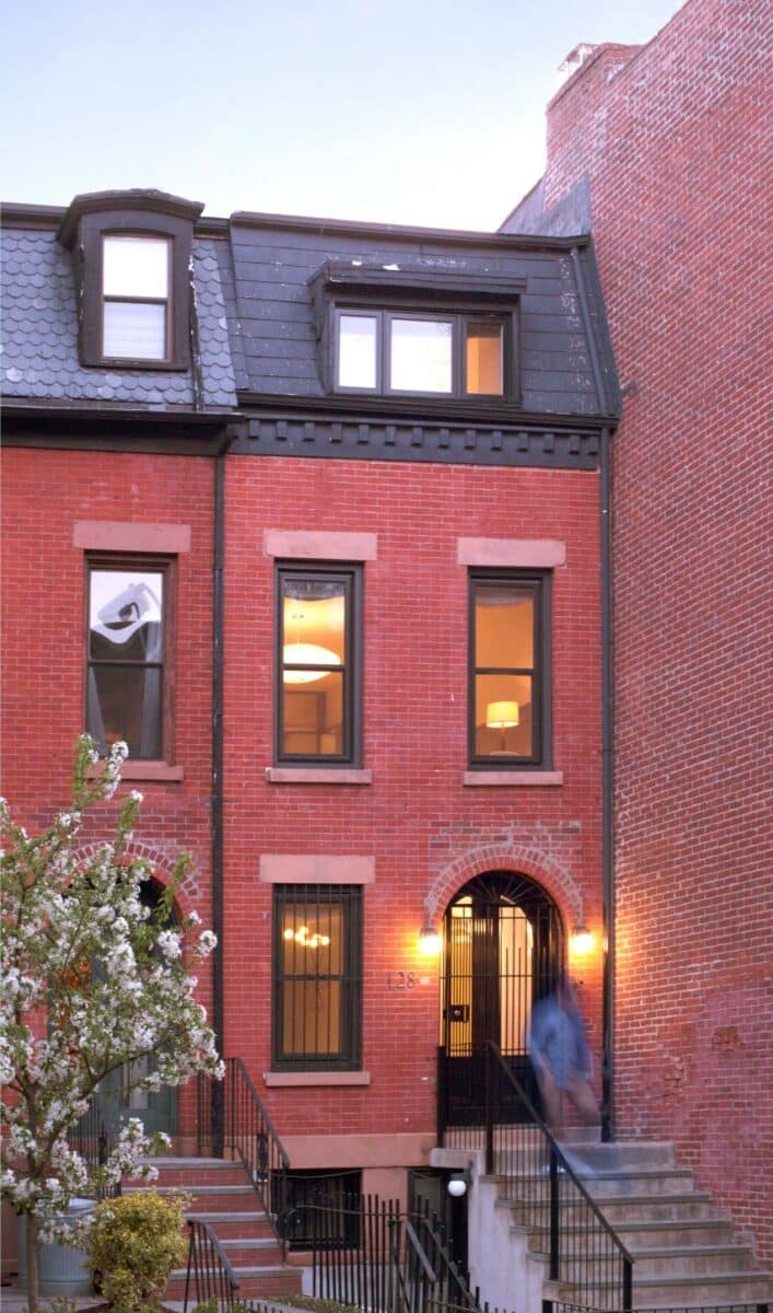 Fotografia do Fort Greene Townhouse, projetado pela GRT Architects, mostrando a escada de vidro na casa estreita de Brooklyn.