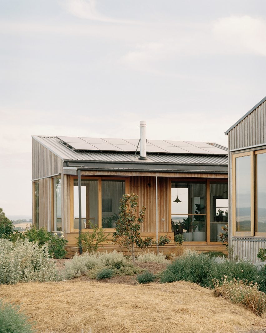 Casa Sustentável e Autossuficiente: A Inovadora Residência Off-Grid. 2 A arquitetura do exterior da Casa Off-Grid da Heather, com foco na auto-suficiência e no design sustentável, cercada pela vegetação nativa.