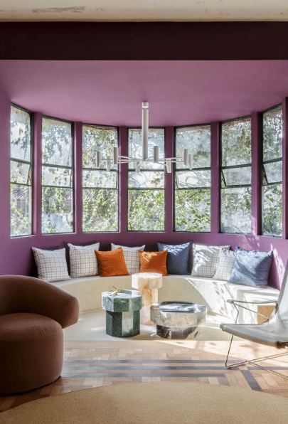 7 Melhores Cores para Sala: Inspirações e Dicas de Combinação 8 Cores para sala: parede roxa + janelas pintadas de verde + móveis curvos – Projeto: Laura Carvalho | Foto: Osvaldo Castro/CASACOR