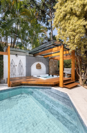 7 Modelos de Pergolado e Dicas para se Inspirar 5 Pergolado de madeira na área externa com jacuzzi e piscina – Projeto: Rafaella Grasnoff – Loft 7 Arquitetura | Foto: Dam Mol