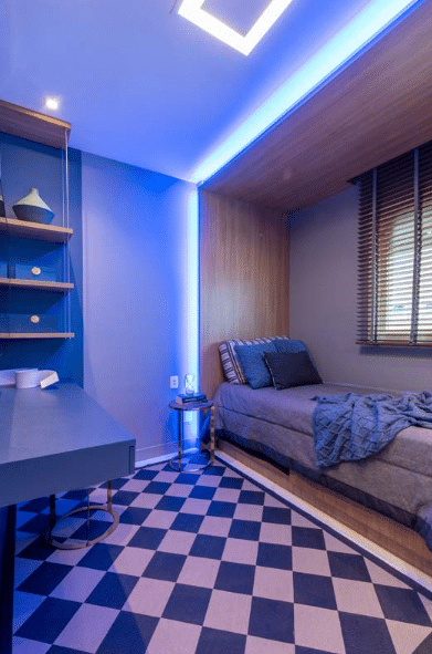 7 Ideias para Decorar Quarto de Solteiro Pequeno 6 Iluminação LED azul + móveis planejados + tapete xadrez – Projeto: Sabrina Salles | Foto: Julia Herman