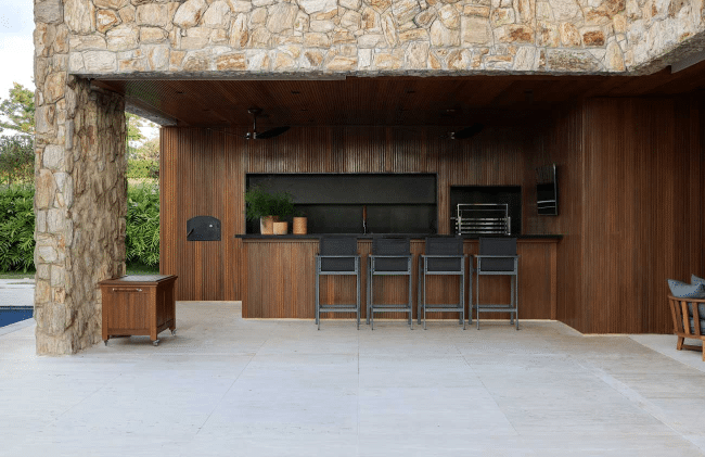 3 Ideias de Revestimento de Parede Externa para Valorizar o Imóvel 4 A madeira traz aconchego e proximidade com a natureza, mas exige cuidados regulares contra umidade, fungos e insetos – Projeto: Marcela Penteado Arquitetos | Foto: @gabriela.daltro