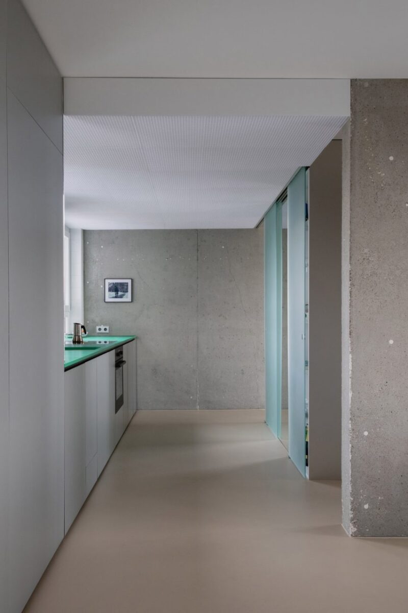 Transformação impressionante de apartamento em Colônia. 3 Cozinha simples com uma parede de concreto ao fundo.