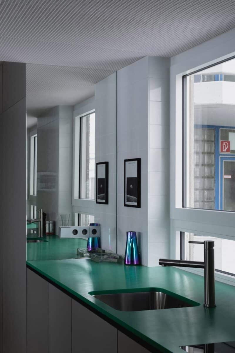 Transformação impressionante de apartamento em Colônia. 4 Cozinha com bancada verde e parede espelhada.
