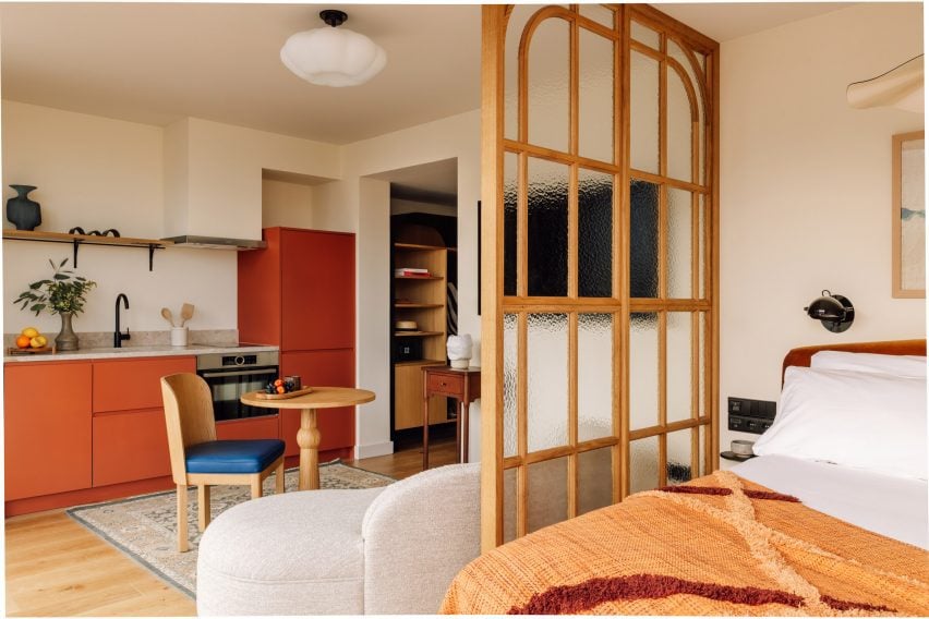 Transformação impressionante: convento se torna hotel luxuoso em Lisboa. 4 Uma das suítes apresenta um espaço dividido por uma parede de vidro e madeira, permitindo a passagem de luz natural e um ambiente acolhedor.