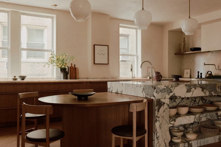 Transformação surpreendente de apartamento em Manhattan com elegância. 4 A cozinha apresenta uma ilha de mármore, combinando elegância e funcionalidade.