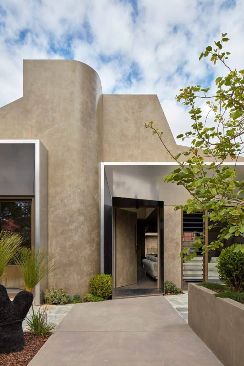 Casa familiar inovadora com revestimento de cânhamo sustentável. 2 Entrada da Proclamation House mostrando a estrutura escultural e o uso do render de cânhamo.