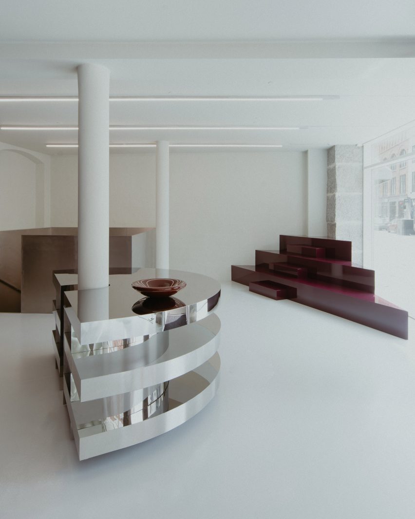 Incrível loja Rotate em Copenhague com design inovador. 2 O balcão espelhado da loja, composto por três semi-círculos empilhados, que serve como área de checkout e exibição.