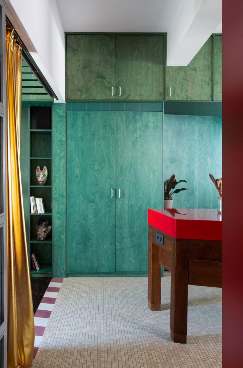 5 interiores criativos em vermelho e verde que encantam. 2 Imagem do apartamento Trikoupi, revelando a parede de armazenamento e os armários vermelhos.