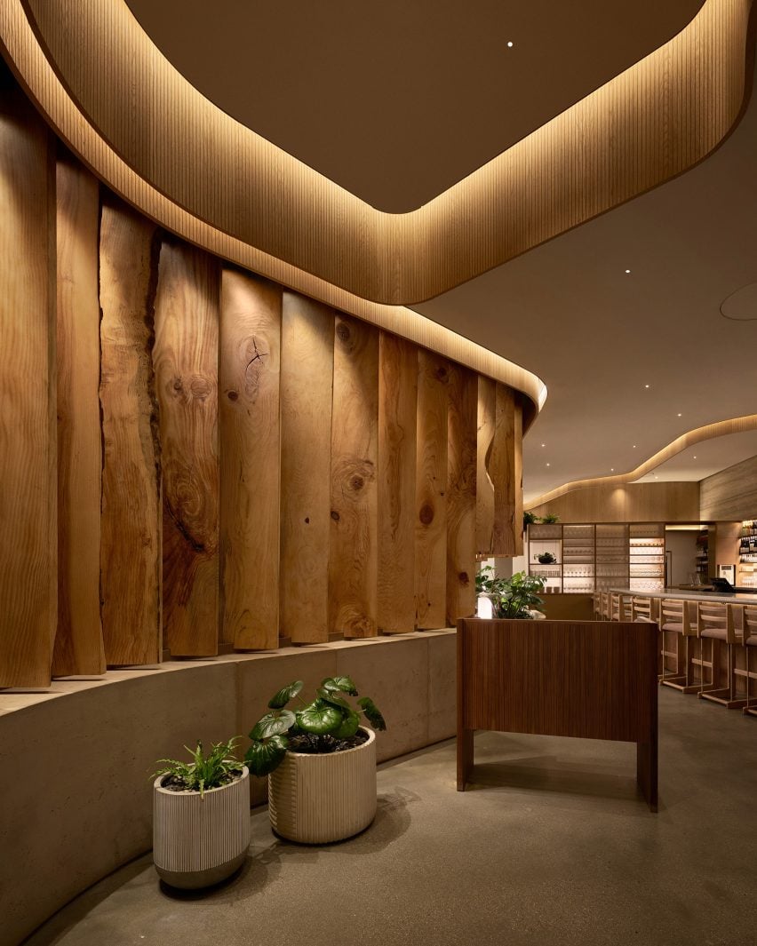 Interior do restaurante Uchi West Hollywood com divisores de espaço feitos de madeira de árvores caídas.