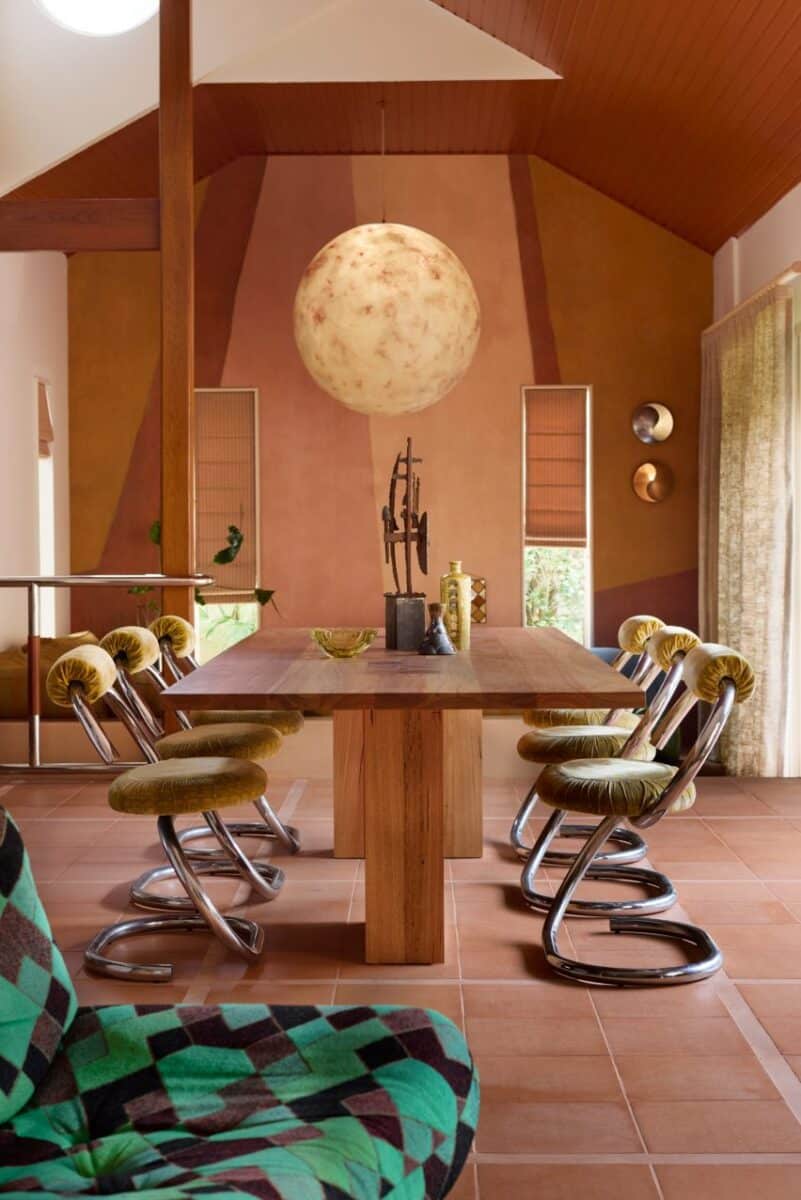 Interior deslumbrante em estilo anos 70 para casa à beira-mar. 3 Área de jantar do Checkmate, com cadeiras de jantar vintage reestufadas em veludo chartreuse.