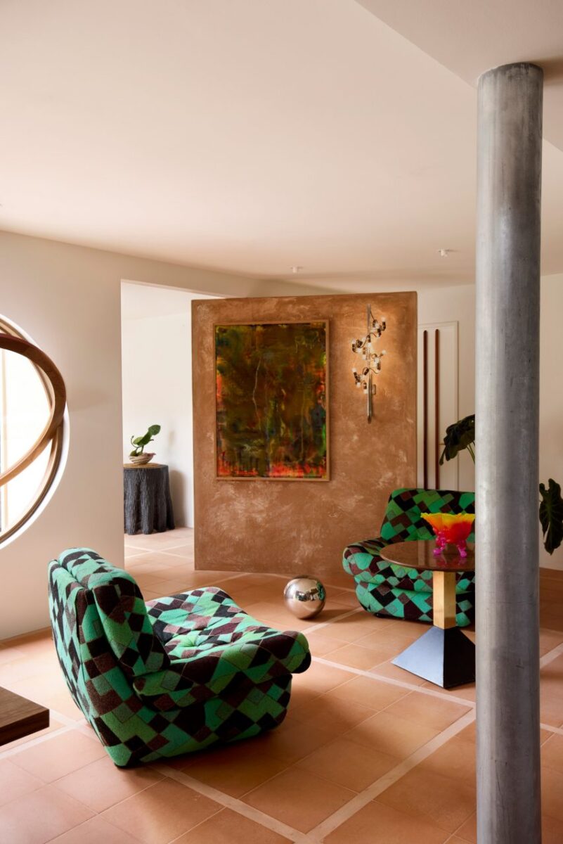 Interior deslumbrante em estilo anos 70 para casa à beira-mar. 4 Sala de estar com poltronas xadrez e pisos de terracota dispostos em um layout geométrico.